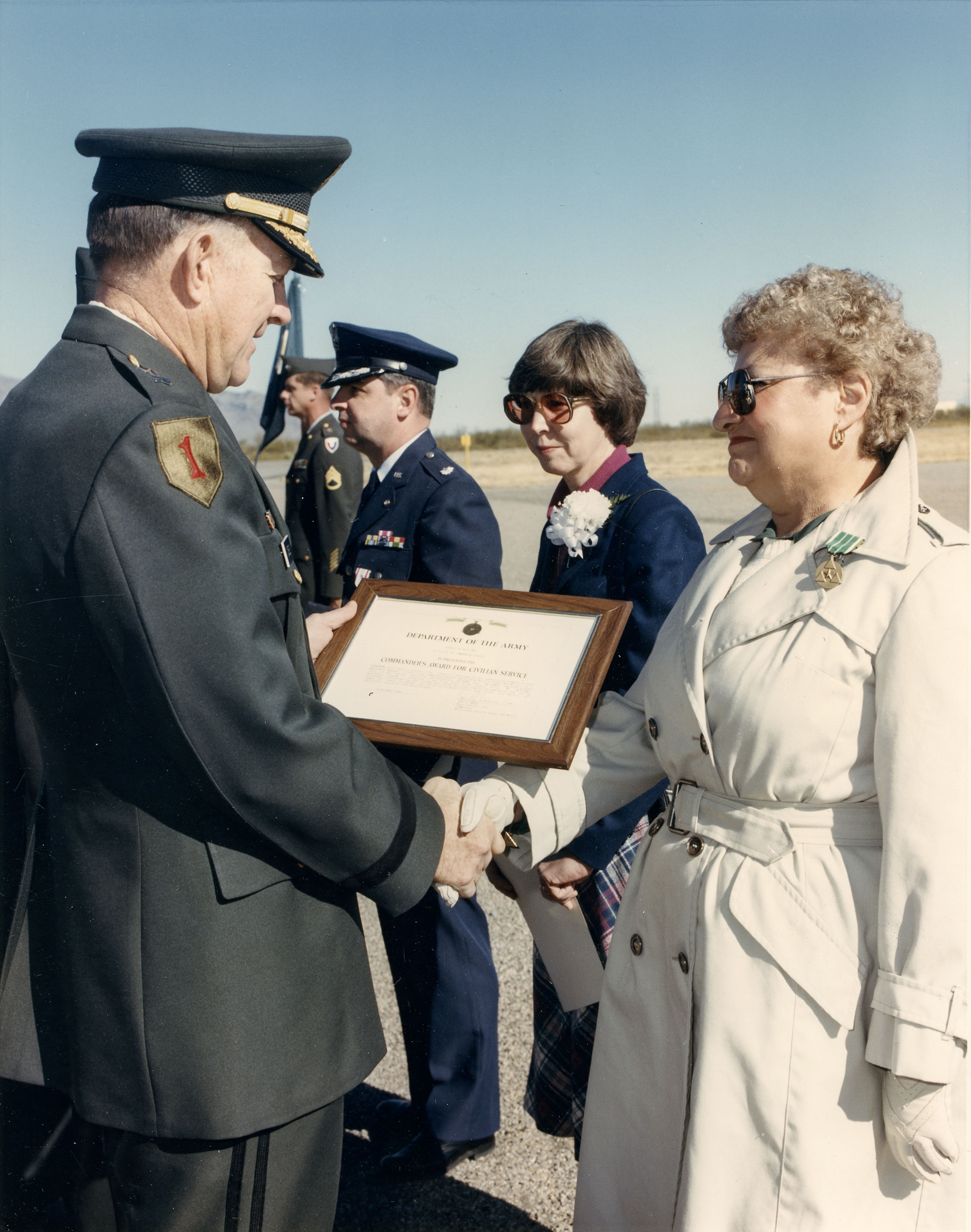 color photograph of five people; three men in military uniform and two women; Frances William received and award from the United States Army