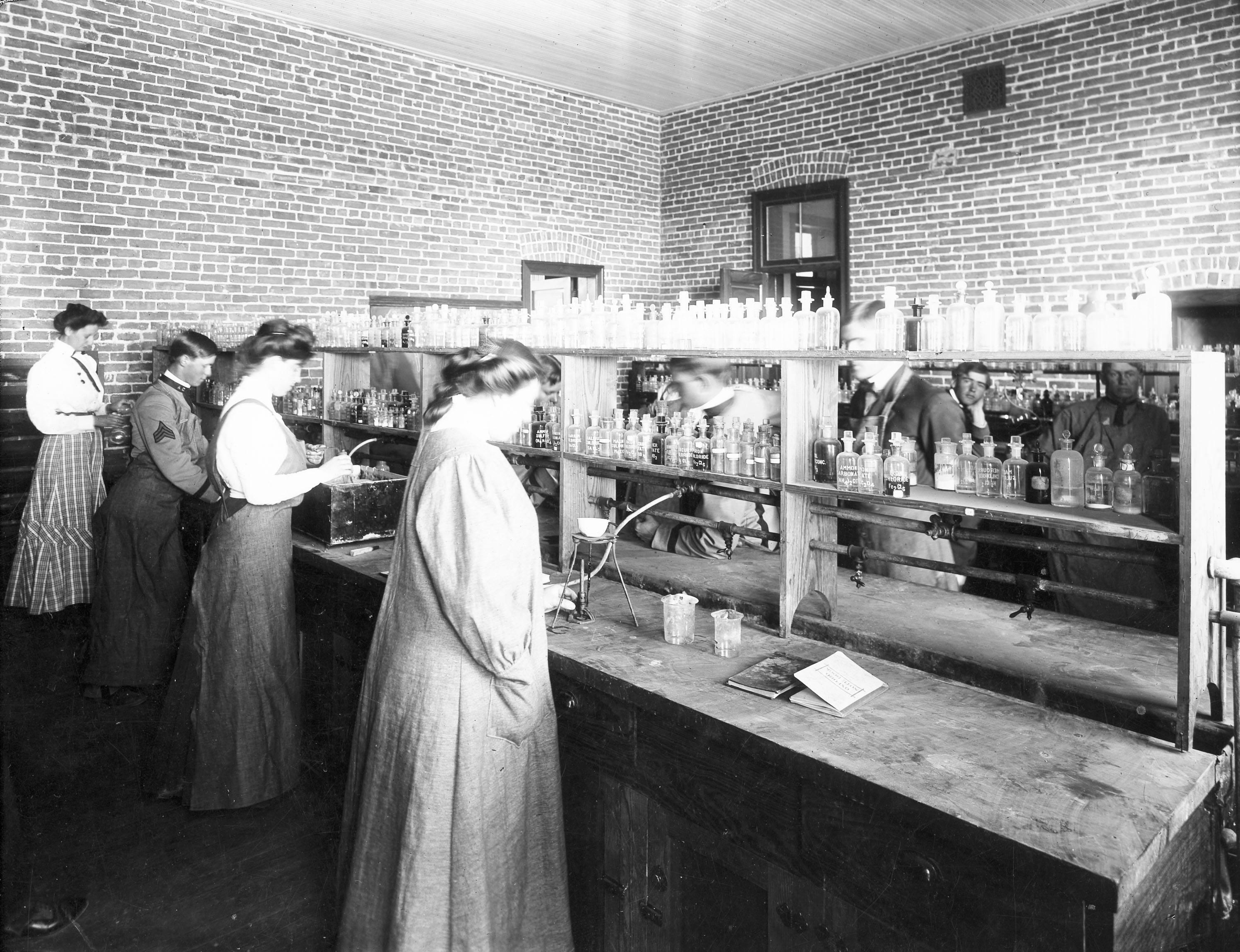 black and white photograph of women in a chemistry lab circa early 1900s