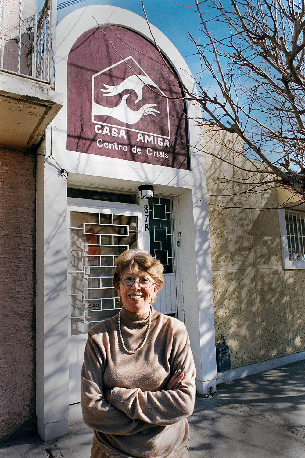 color photograph of Esther Chavez Cano standing in front of Casa Amiga
